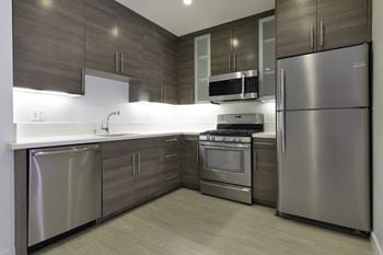 A kitchen with stainless steel appliances and wooden cabinets